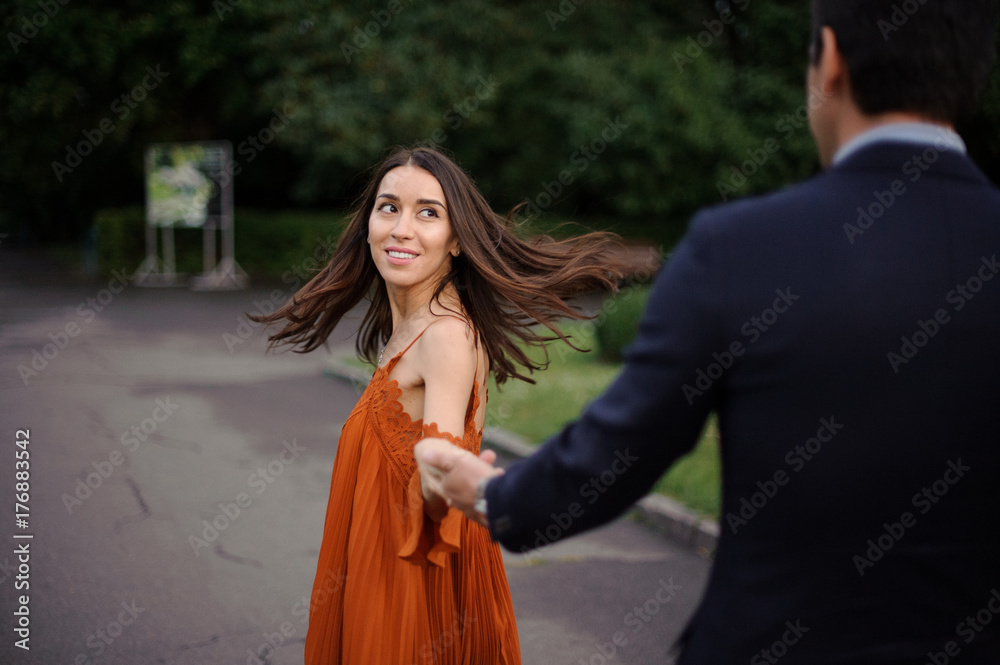 Fototapeta premium Beautiful woman looking on her boyfriend holding his hand