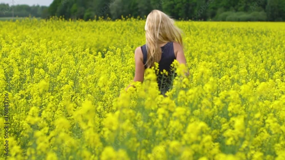 young blonde woman posing in beautiful rapeseed field young blonde woman posing in beautiful rapeseed field