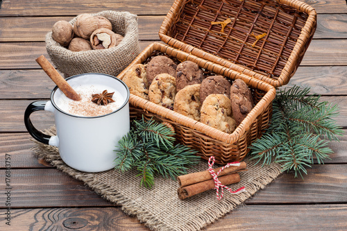 eggnog cocktail in  mug arranged with christmas decoration and cookies box on wooden table