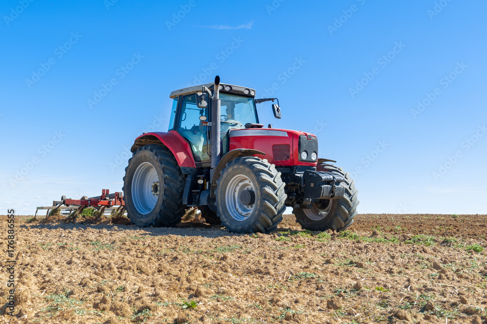 agricultural tractor in the foreground with blue sky background. agricultural tractor in the foreground with blue sky background.