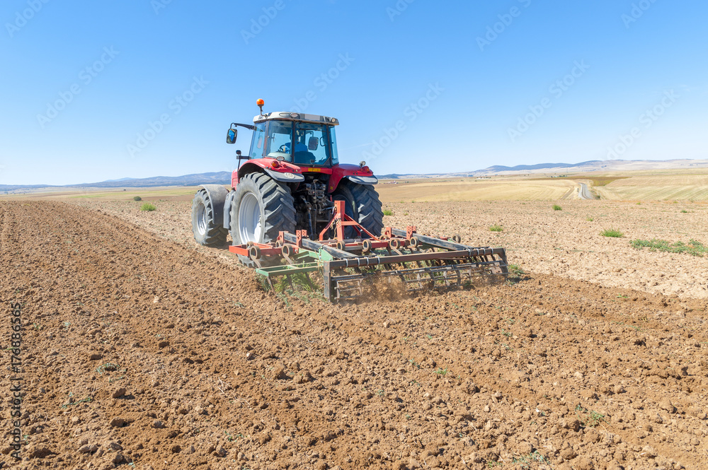 agricultural tractor in the foreground with blue sky background. agricultural tractor in the foreground with blue sky background.