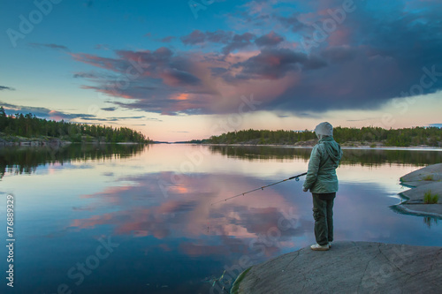 A lonely fisherman. Fishing on the shore of the lake. Karelia. Russia. Ladoga lake.