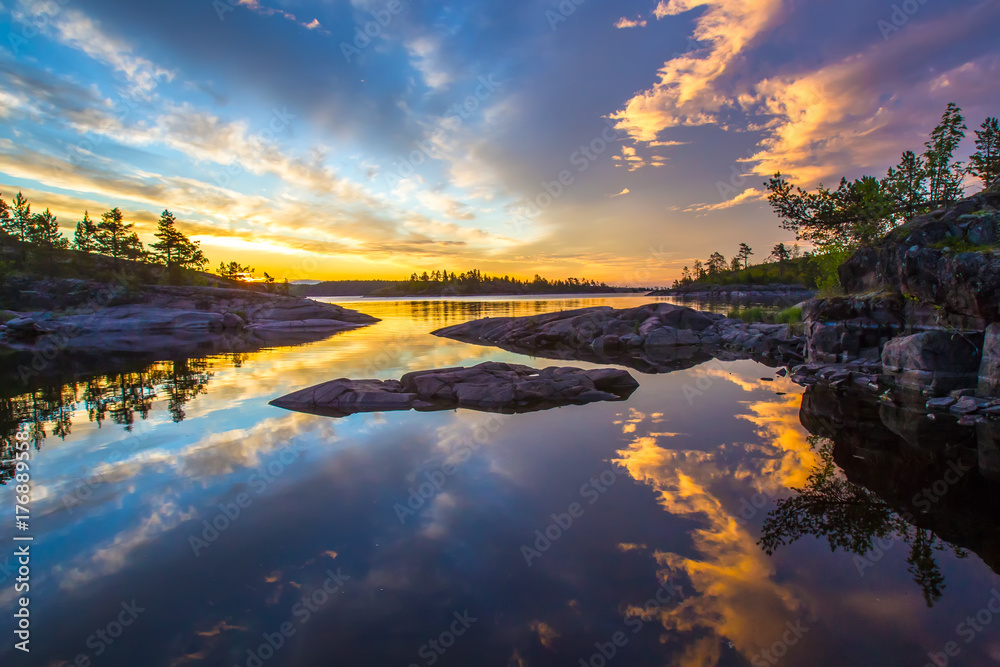 Russia. Karelia. Mirror reflection in water. Stones in the water. Ladoga lake.