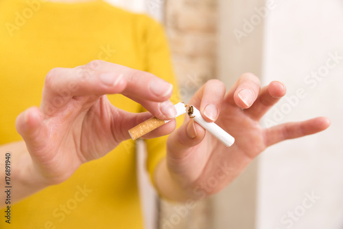 Young woman is breaking a cigarette, quit smoking concept