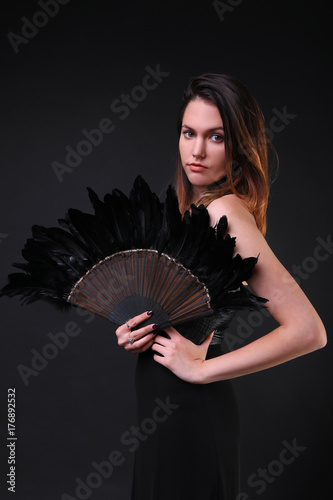 Young woman with a black feather fan and hat