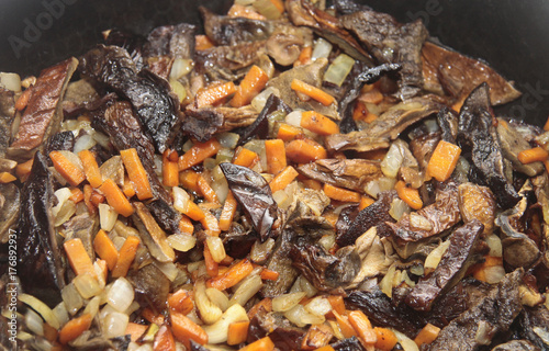 Mushrooms fried on the pan with carrot and onion