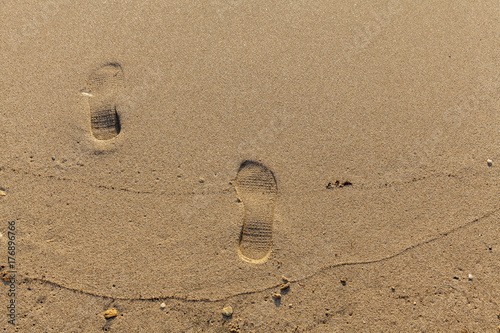 two footprint in send on beach photo