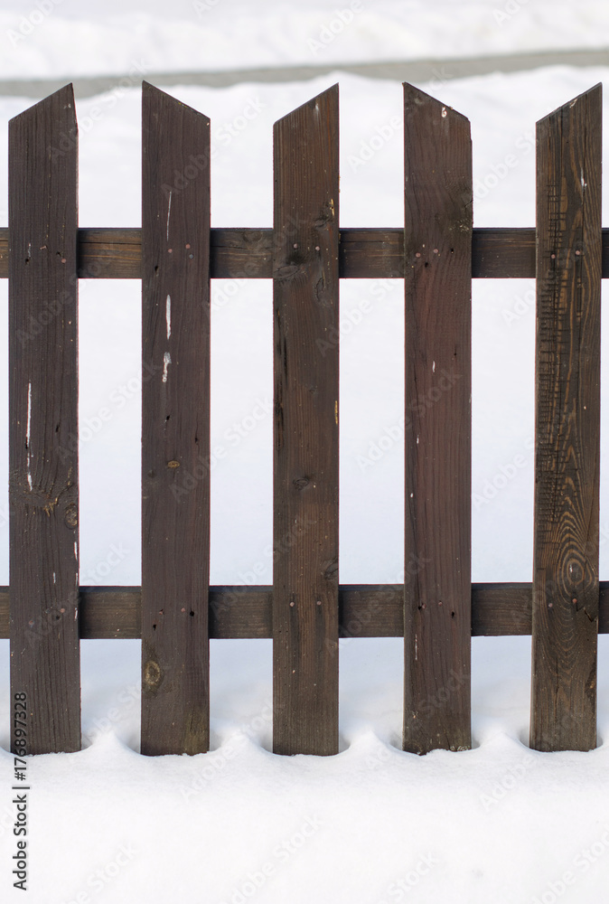 Old wooden fence surrounded by snow. Christmas and winter concept.