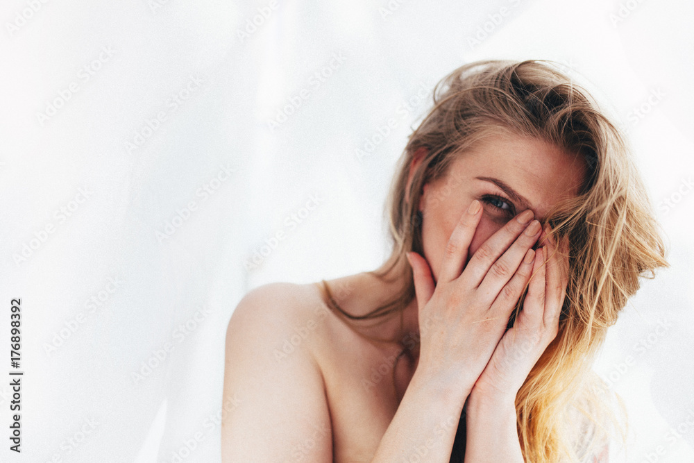 Charming woman hiding her face with her hands Charming woman hiding her face with her hands