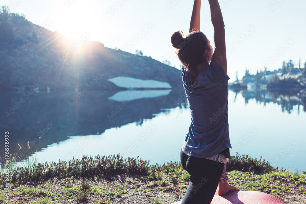 Φωτογραφία Fit young happy traveling woman practicing yoga outdoor in the stunning mountain wilderness in front of amazing cold lake