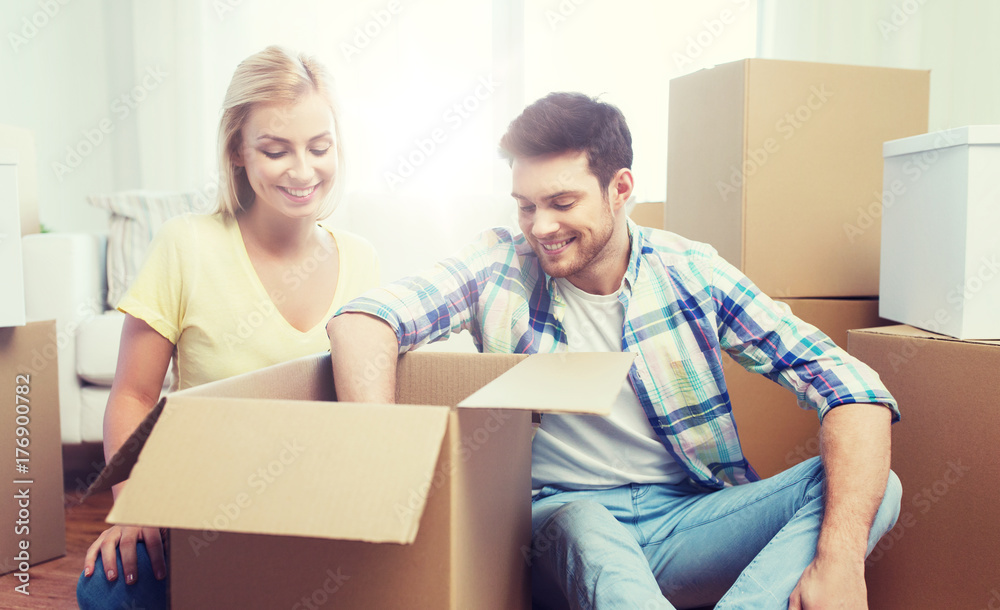 smiling couple with big boxes moving to new home smiling couple with big boxes moving to new home