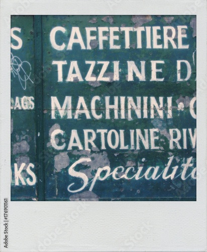 Old  snapshot print Italian words painted on a chipped green wall photo