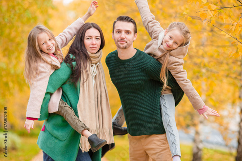 Beautiful happy family of four in autumn day outdoors