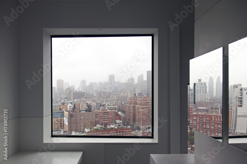 Photography A view of New York City skyline from a window and a reflection on the mirror
