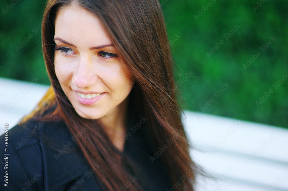 Portrait of beautiful smiling Caucasian white girls on blurred green background. A woman natural beauty with long hair, selective focus, close-up.