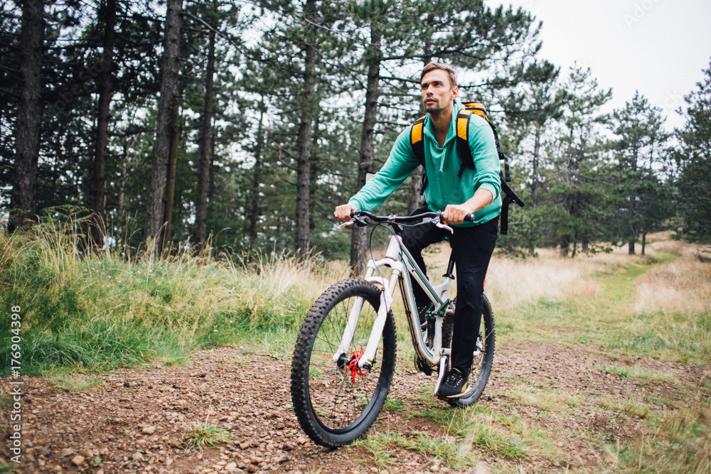 Young man riding a mountain bike through forest Young man riding a mountain bike through forest