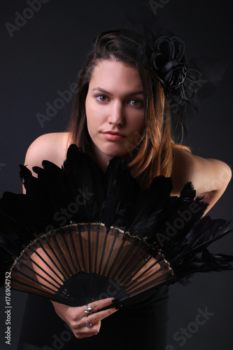 Young woman with a black feather fan and hat