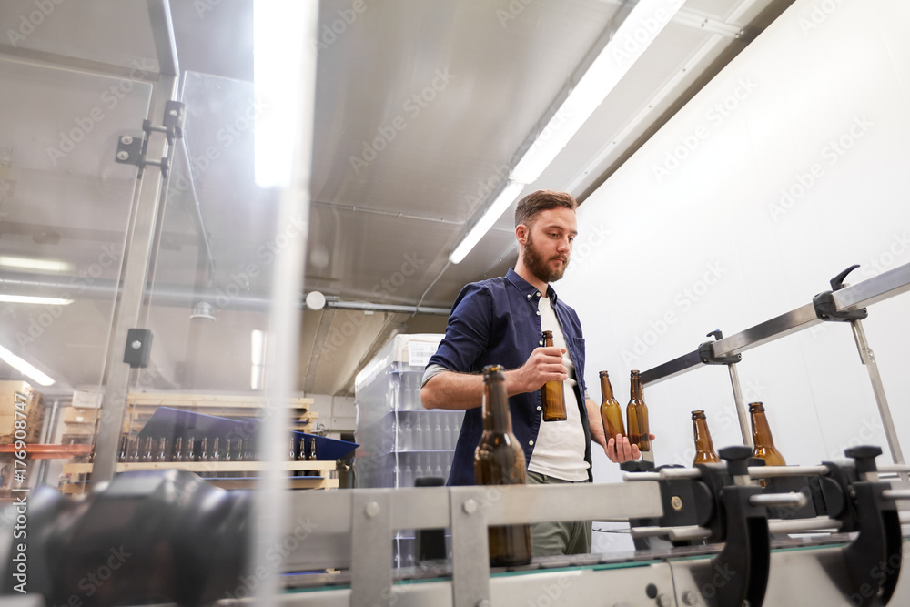 men with bottles on conveyor at craft beer brewery