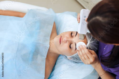 Face skin care. Young woman getting facial ultrasound cleaning photo