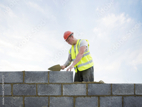 Bricklayer building internal wall of new house.