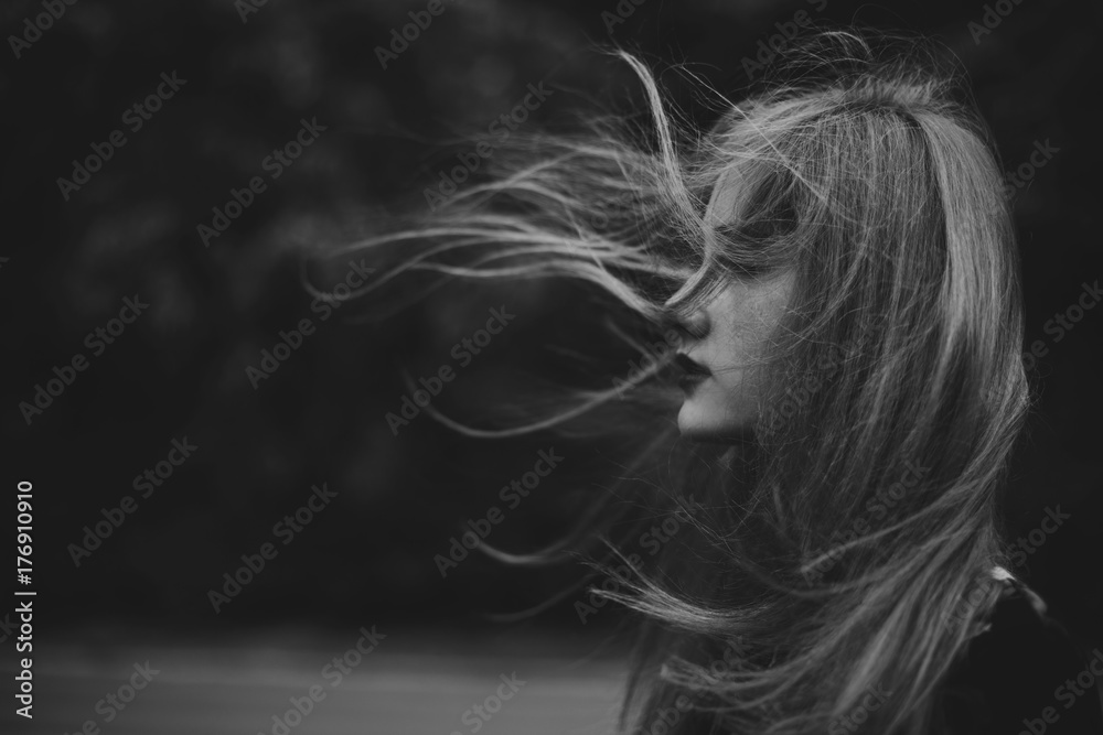 Young woman with hair blowing in the wind Stock Photo | Adobe Stock