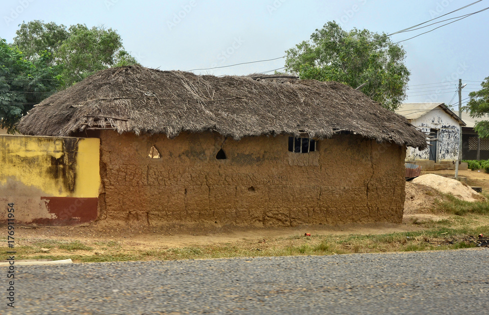 African village. Traditional clay house with thatched roof. Rural area.