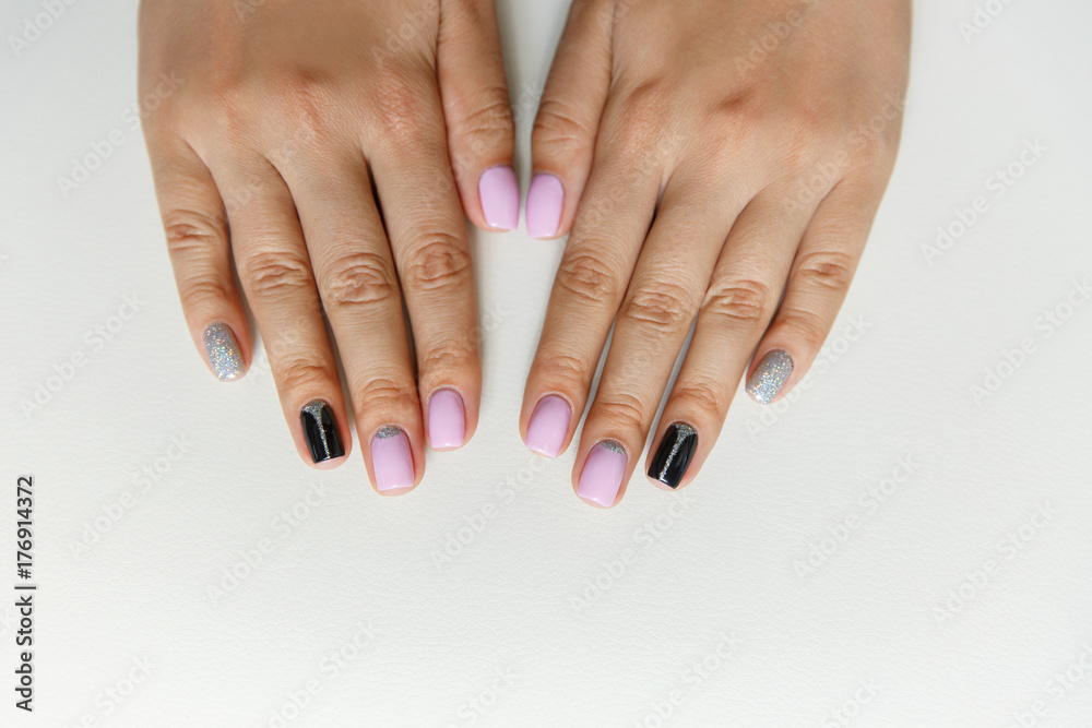 Natural nails with colorful manicure, pink, black and silver polish on women nails. Nails of woman with creative ornament, festive and interesting design manicure on white isolated background Natural nails with colorful manicure, pink, black and silver polish on women nails. Nails of woman with creative ornament, festive and interesting design manicure on white isolated background