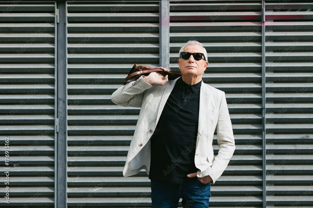 Smiling senior businessman walking on the street.