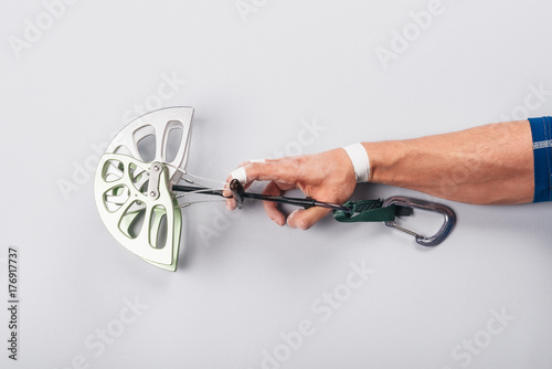 Male climber hand holding a camming device