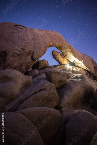 Flashlight Lit Arch Rock Under Night Sky in Joshua Tree National Park, California