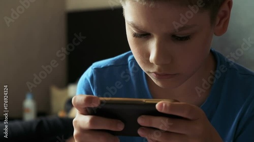 Child with mobile phone indoors. Portrait of boy with mobile phone. Growing up technology addiction concept use smartphone app for online browsing or watch video