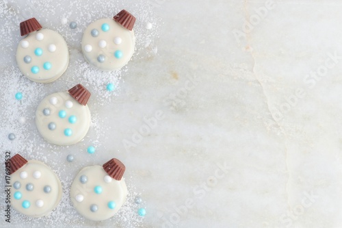 Christmas white chocolate ornament cookies, side border on a white marble background