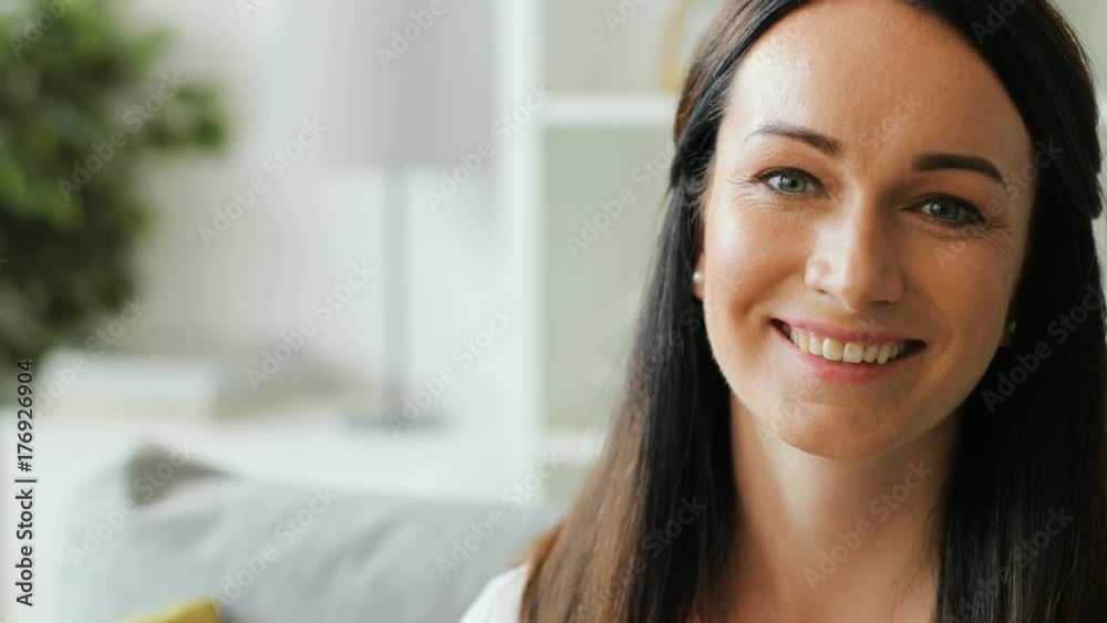 Beautiful happy young woman looking to the camera and smiling at home in the living room. Close up. Beautiful happy young woman looking to the camera and smiling at home in the living room. Close up.