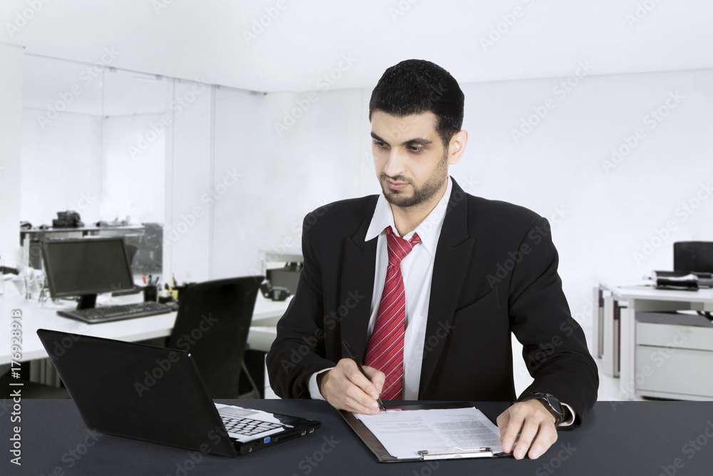 Handsome Arabian businessman works in office Handsome Arabian businessman works in office