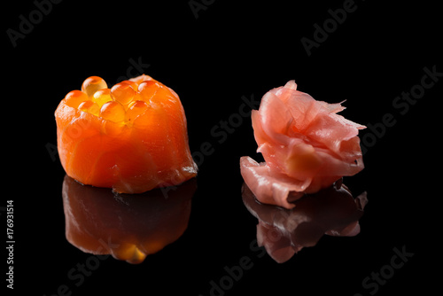 Sushi salmon with caviar and ginger isolated on black background