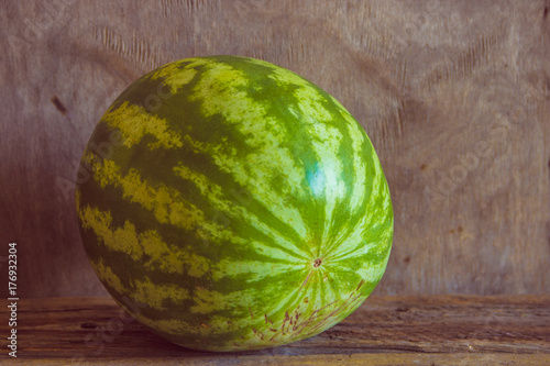 Whole watermelon on the wooden background