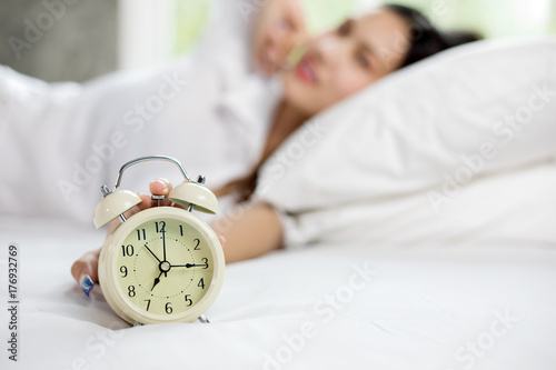 asian woman happy wake up and turning off the alarm clock having a good day