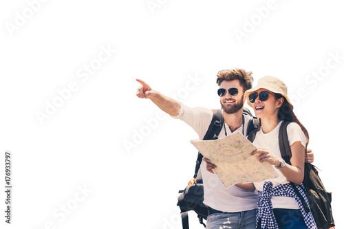 Multi ethnic couple look at map while pointing finger in the direction of destination. Travel concept. Honeymoon trip, backpacker tourist, Asia tourism or holiday vacation travel concept. Isolated.