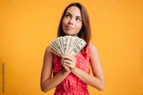 Ταπετσαρία Young attractive smiling woman thinking how to spend her bunch of money