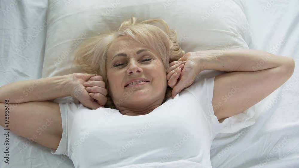 Attractive woman waking up and stretching hands, good morning, health and beauty Attractive woman waking up and stretching hands, good morning, health and beauty