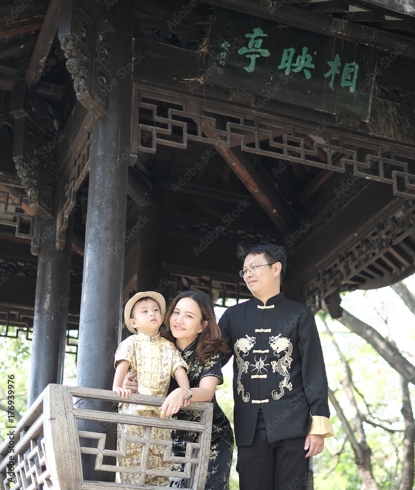 middle aged of Chinese family in Chinese black outfit at the park in summer .