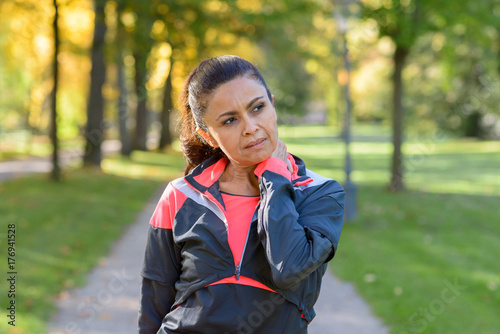 Woman holding her painful neck in park © michaelheim