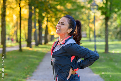 Fényképezés Woman holding painful back in park