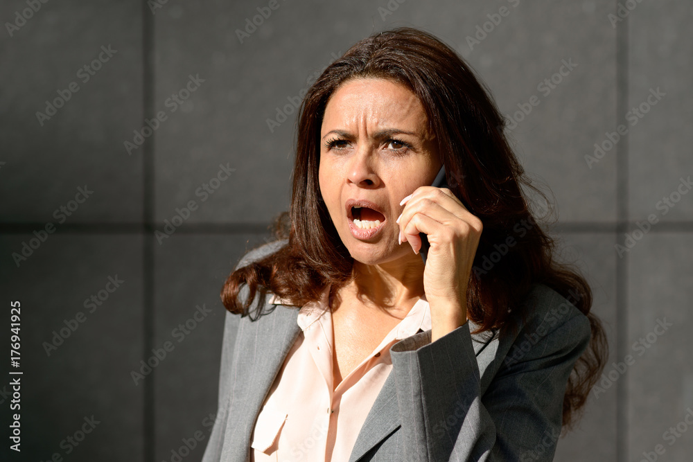 Emotional woman speaking on her mobile phone Emotional woman speaking on her mobile phone
