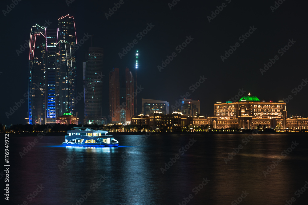 Abu Dhabi buildings skyline from the sea at night
