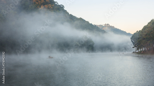 Environmental Friendly Outdoor Activity, Floating Bamboo Rafting in the morning in serene lake with sunlight and mist water surrounded by valley and mountain ranges, Pang Oung, Mae Hong Son, Thailand