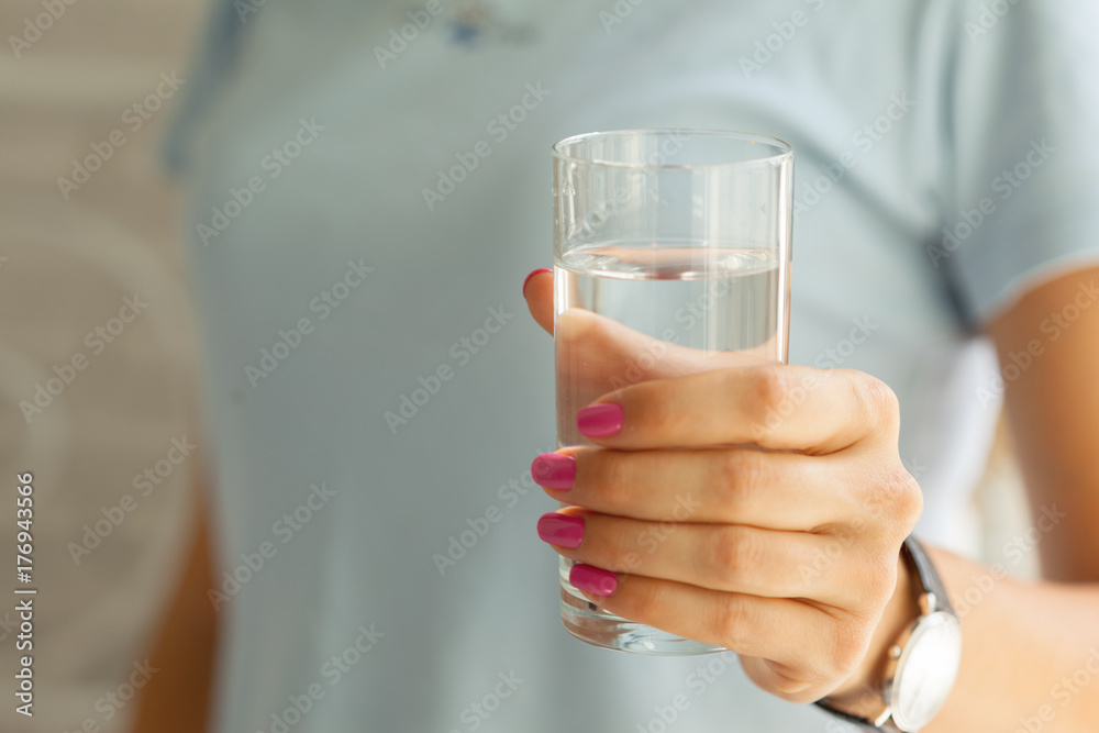 Woman holding a glass of water, close-up Woman holding a glass of water, close-up