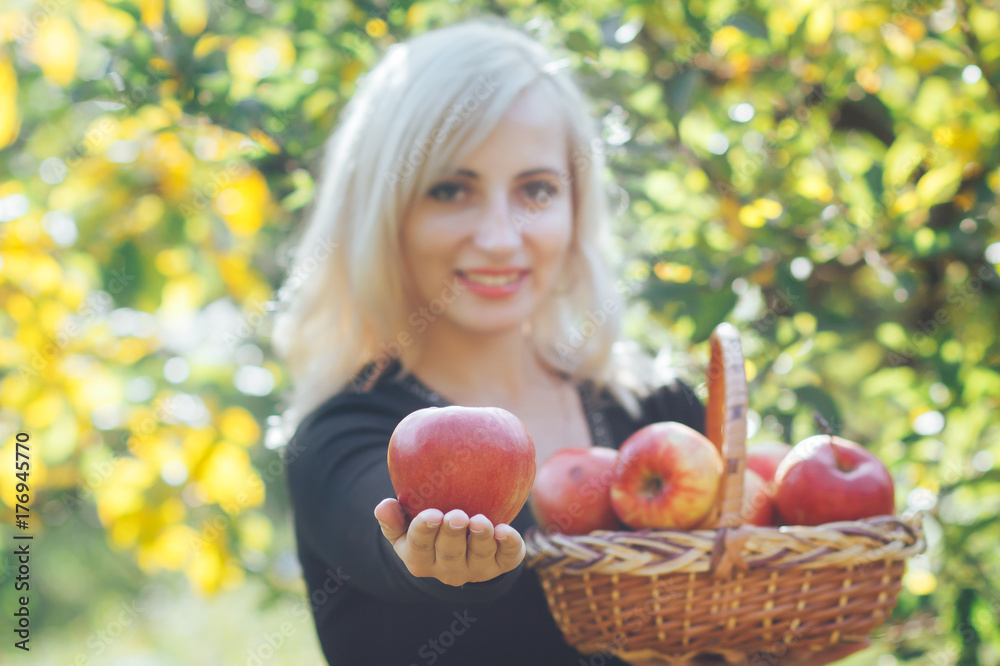 A girl is holding a ripe red apple in her hands. Focus on the apple. A girl is holding a ripe red apple in her hands. Focus on the apple.