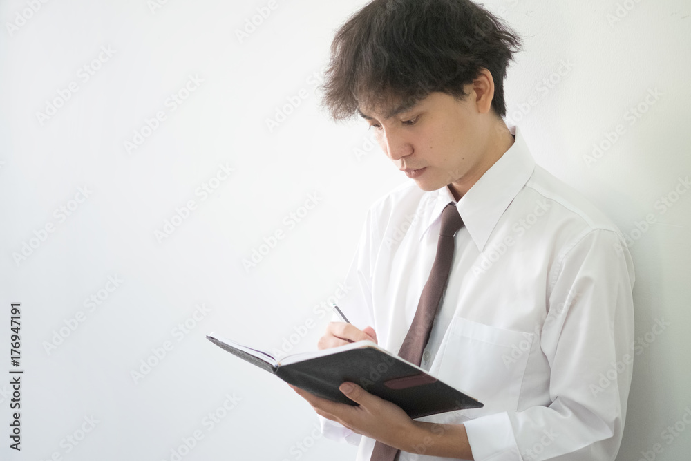 Business asian man writing something on notepad paper in office. Business asian man writing something on notepad paper in office.