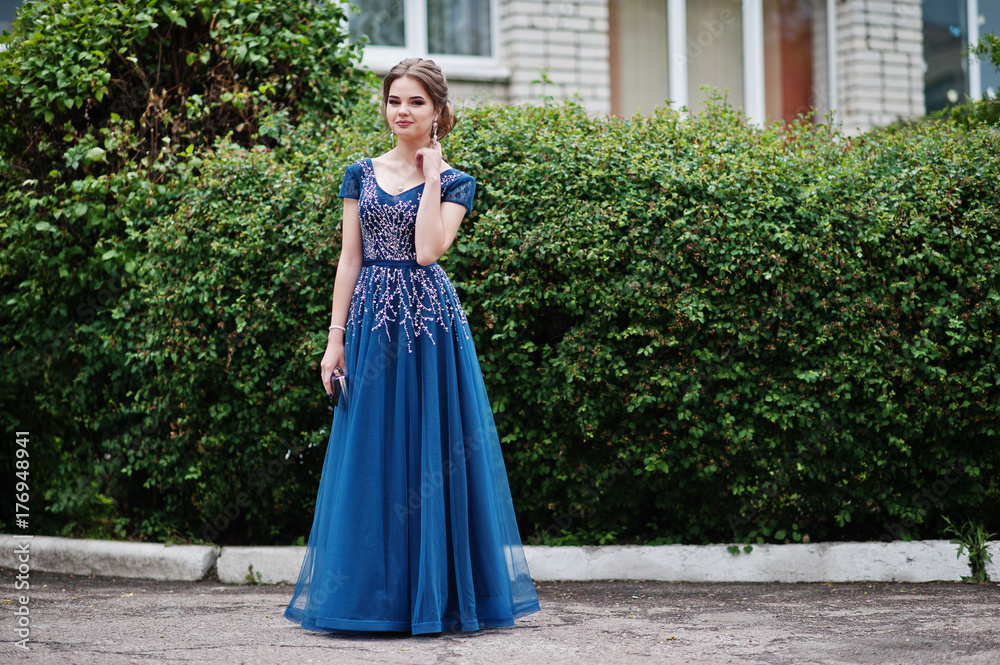Fototapeta premium Portrait of a beautiful and gentle girl in elegant gown posing outdoor.